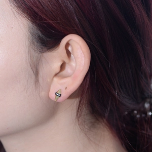 Gros plan sur un clou d'oreille géométrique en or avec émail noir et zircons cubiques