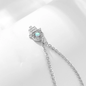 Macro detail of silver Hamsa Hand pendant with inset opal and micro-pave zircons