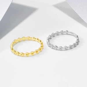 Detailed view of leaf-shaped rings in gold and silver showing S925 sterling silver hallmarks