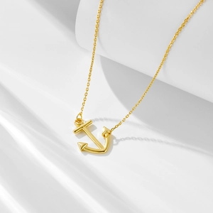 Polished gold anchor pendant necklace with O-chain on minimalist white background