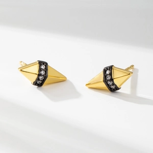 Détail macro du clou d'oreille doré géométrique avec émail noir et petits zircons