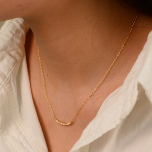 Close-up of a silver smile pendant necklace with sparkling zircons on a female model