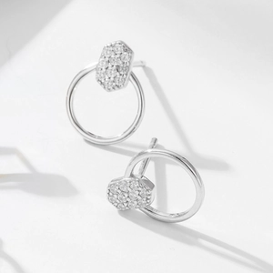 Gros plan sur les boucles d'oreilles hexagonales en argent serties de zircones cubiques