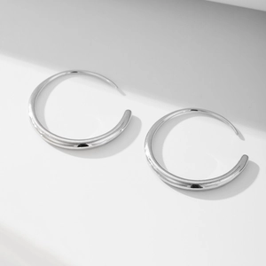 Polished silver geometric hoop earrings with reflective mirror finish on white background