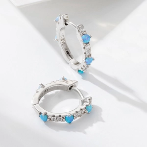 Macro shot of S925 sterling silver stamp and blue opal inlay on small hoop earrings