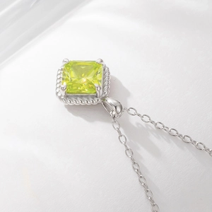 Close-up of square cut green zircon pendant with twisted rope border on silver chain