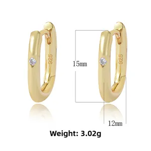 Detail view of 925 sterling silver gold U-shaped huggie earrings with diamond accent