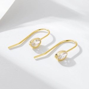 Detailed view of elegant gold-plated U-shaped earrings with oval cubic zirconia setting