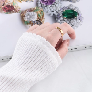 Detail of a minimalist gold chain texture ring worn on hand for a modern fashion look