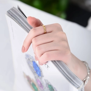 Chic gold-toned sterling silver cuban chain link ring worn against a magazine background