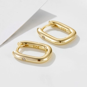 Macro detail of gold-plated geometric rectangle hoop earring with S925 hallmark and zircon