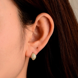Close-up of gold-plated teardrop hoop earrings with pavé-set cubic zirconia on a model