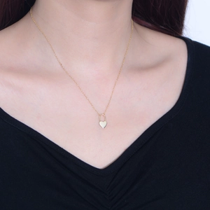 Minimalist S925 sterling silver heart locket necklace worn by a model on a black top