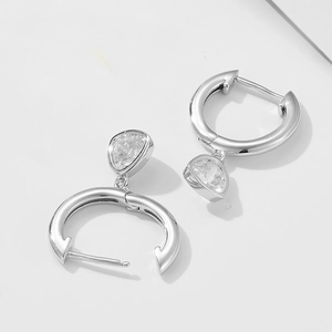 Macro detail of silver hoop earrings with teardrop zirconia in open and closed views