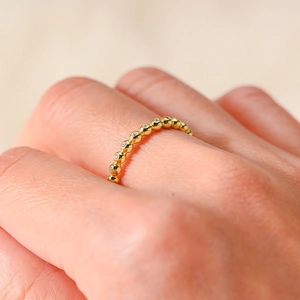 Gros plan sur la bague perlée dorée ornée de zircons étincelants pour femmes
