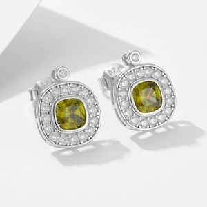 Macro shot of S925 silver halo earrings featuring olive green cushion-cut stones