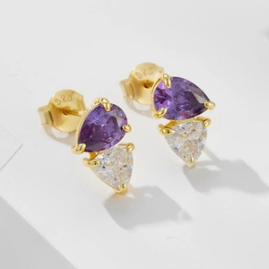 Macro shot of 925 sterling silver pear-shaped purple zircon earrings with gold plating