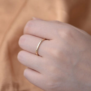 Anello minimalista in argento sterling s925 placcato oro sulla mano con sfondo in seta elegante
