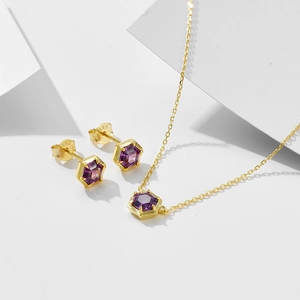 Macro shot of 925 silver gold-plated hexagon amethyst pendant and matching stud earrings