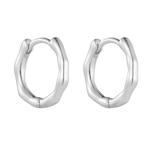 Gros plan de boucles d'oreilles créoles vagues argentées avec finition métal poli