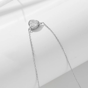 Macro shot of silver triangle zircon pendant necklace with delicate chain detailing