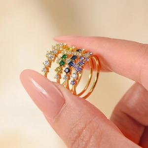 Stackable gold-plated silver rings with multi-color gemstones in a soft luxury style