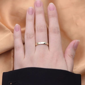 Close-up of golden four-leaf clover ring with small diamonds on silk background