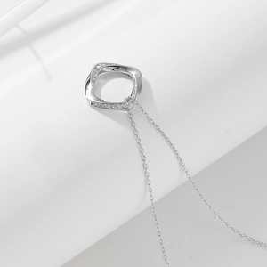 Gros plan du collier géométrique argenté avec pavé de cristaux et éclat métallique poli