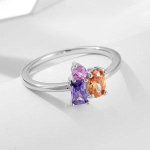 Detail of silver ring featuring prong-set pink round, purple rectangular and orange oval gems