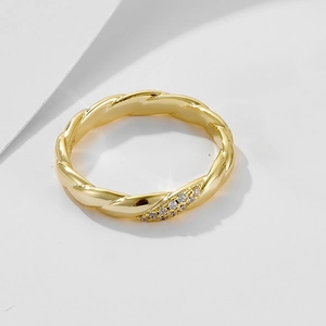 Macro detail of gold twist band ring with sparkling pavé cubic zirconia accents