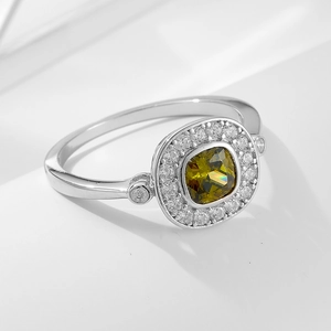 Détail d'une bague vintage en argent s925 avec zircon vert olive et halo de coupe coussin