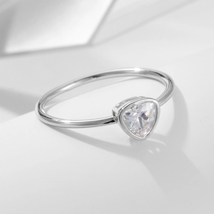 Macro shot of minimalist silver ring featuring a bezel-set triangle cut zircon stone