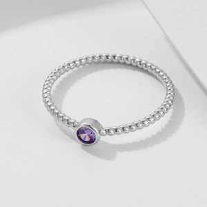 Macro view of a twisted silver ring band with a round purple amethyst bezel setting