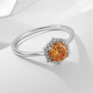 Lussuoso anello in argento S925 con zircone champagne e halo di diamanti su sfondo bianco