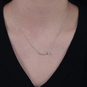 Macro detail of a 925 silver smile necklace with a white pearl and sparkling crystals