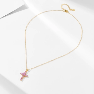 Detail of gold chain necklace with pink zircon cross pendant and extension link