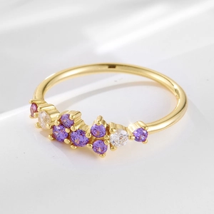 Detailed macro view of 18K gold ring with cluster of purple and white zircon stones