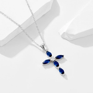 Elegant sterling silver necklace with a cross pendant featuring marquise-cut blue zircons