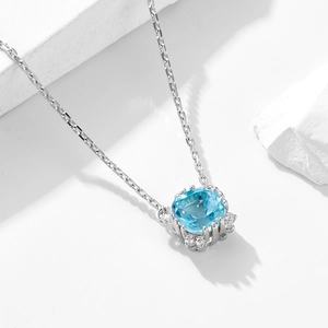 Elegant 925 sterling silver necklace featuring a cushion-cut blue topaz halo pendant