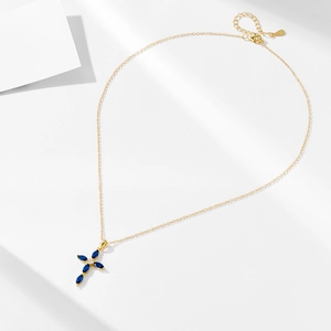Detailed view of S925 sterling silver stamp and blue zircon cross pendant on gold chain