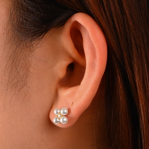 Macro view of S925 silver flower stud earrings with four pearls and a central zircon