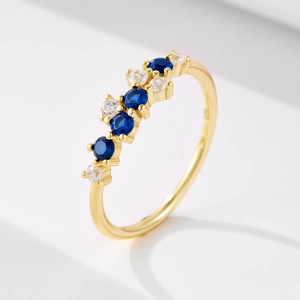 Detail of S925 silver gold ring with blue sapphires and white cubic zirconia stones