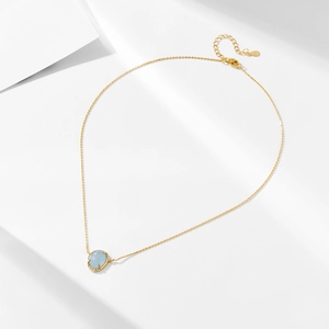 Detail of S925 hallmark on gold plated silver chain with blue gemstone pendant