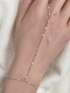 Detailed view of s925 silver hand harness with oval metal plates and dainty finger chain