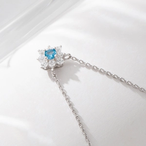Close-up of S925 silver flower pendant necklace with blue gemstone and white zircon
