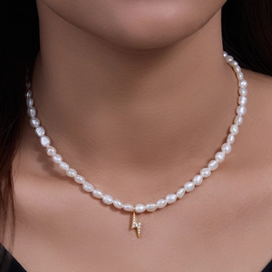 Elegant freshwater pearl necklace featuring a gold lightning bolt pendant on a model