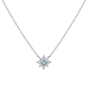 Macro shot of silver floral pendant necklace with a blue center stone and zircon petals