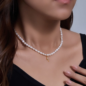 Detail of baroque pearl necklace with a gold crystal-encrusted lightning bolt pendant