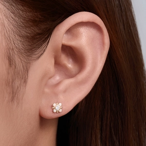 Close-up of a 925 silver gold-plated geometric earring with opal and diamonds on ear