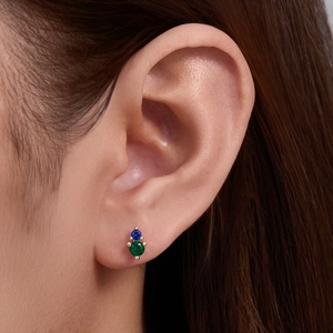 Macro shot of 925 silver gold-plated stud earring with blue and green opal stones